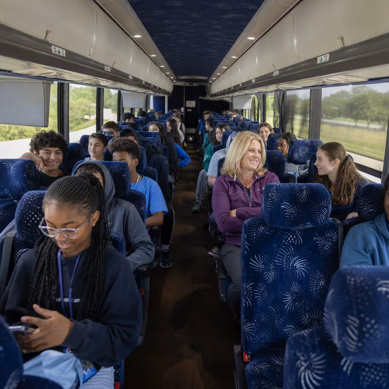 Group boarding a white charter bus for School Transportation transportation in Lancaster