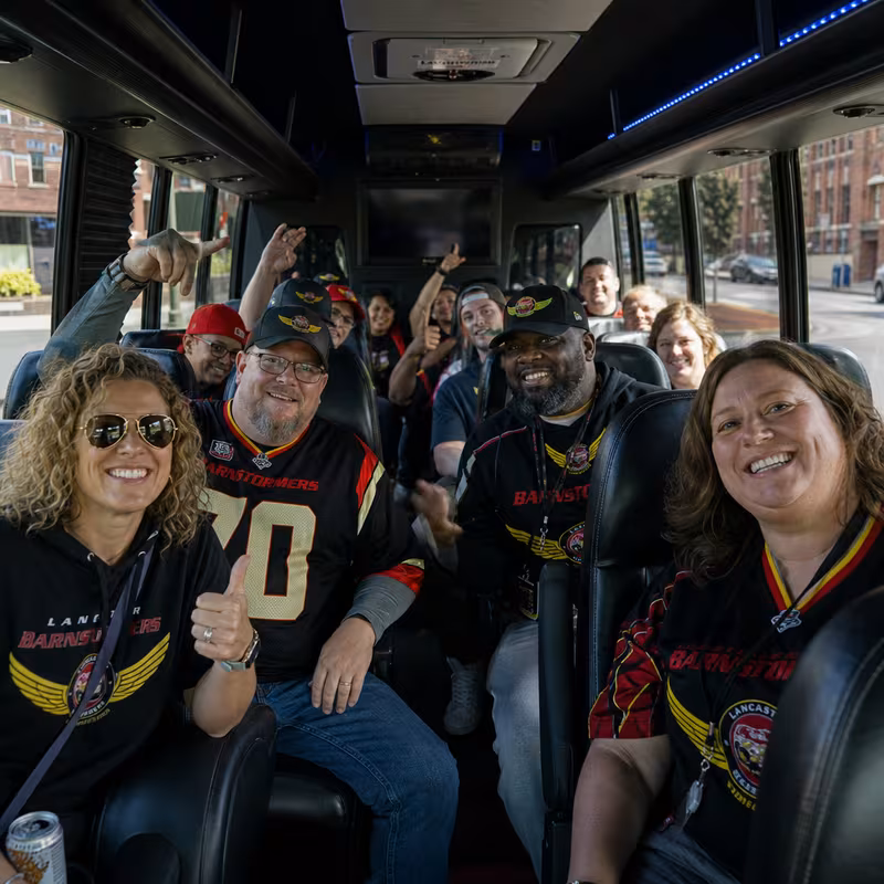 Group boarding a white charter bus for Sporting Event Transportation transportation in Lancaster